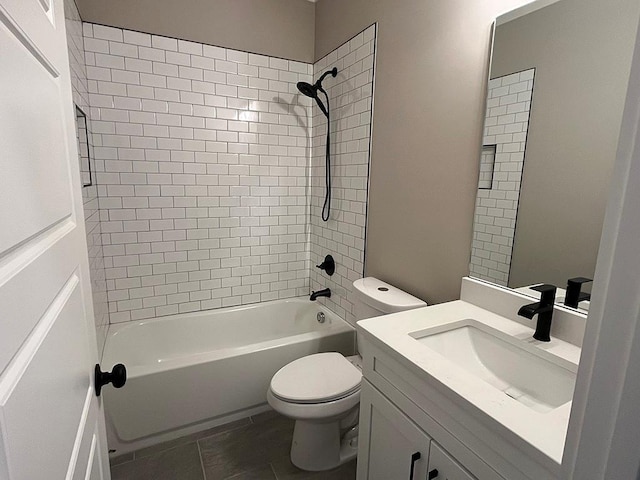 full bathroom featuring tile patterned flooring, vanity, tiled shower / bath, and toilet