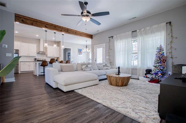 living room featuring beam ceiling, ceiling fan with notable chandelier, and dark hardwood / wood-style flooring