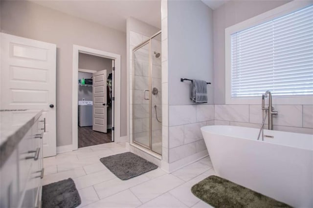 bathroom featuring shower with separate bathtub, vanity, tile patterned floors, and tile walls