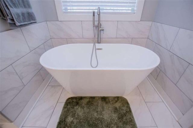 bathroom featuring a tub and tile walls