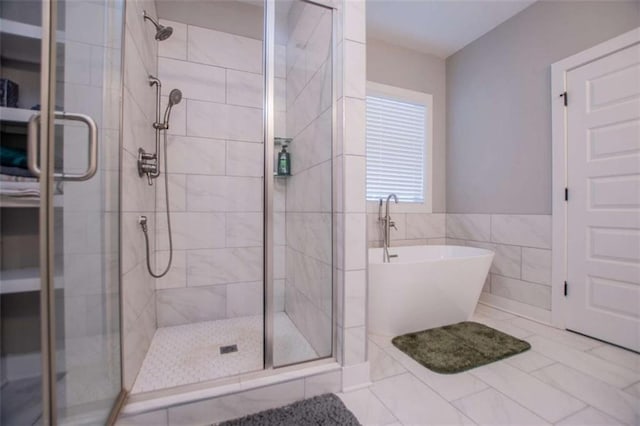 bathroom featuring plus walk in shower and tile walls