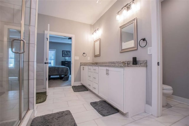 bathroom featuring a shower with door, vanity, and toilet