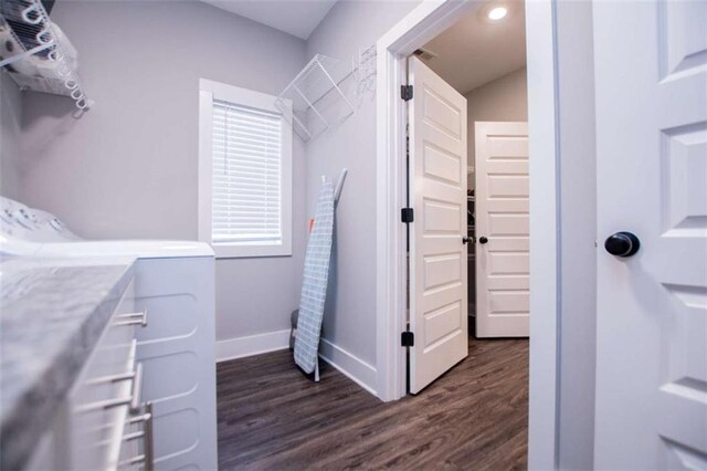 laundry area with dark hardwood / wood-style floors and washing machine and clothes dryer