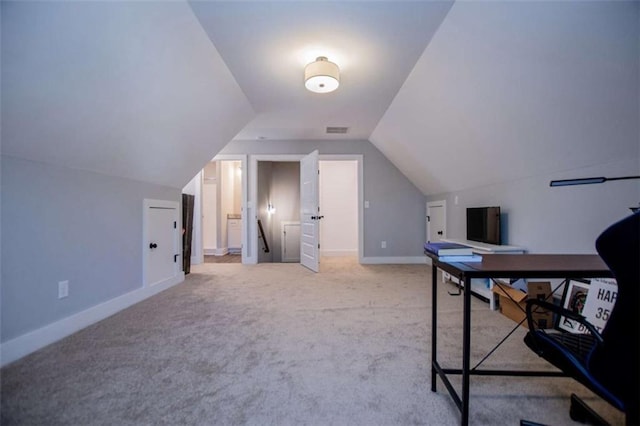 carpeted home office with lofted ceiling