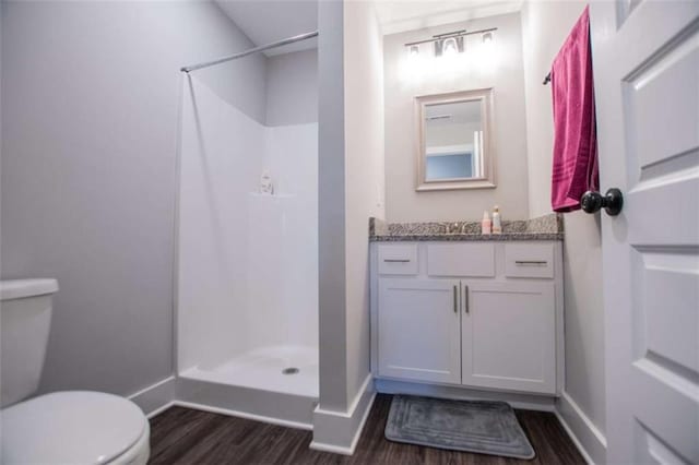 bathroom featuring a shower, wood-type flooring, vanity, and toilet