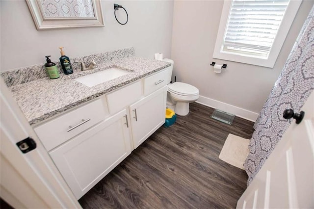 bathroom featuring vanity, wood-type flooring, and toilet