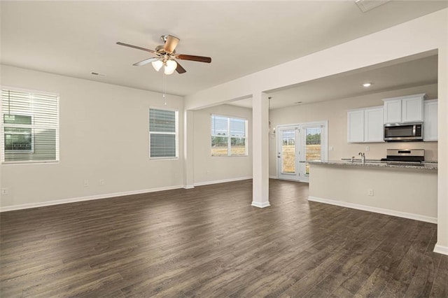 unfurnished living room featuring ceiling fan and dark hardwood / wood-style floors