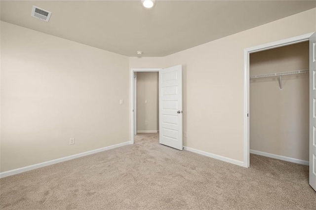 unfurnished bedroom with light carpet and a closet