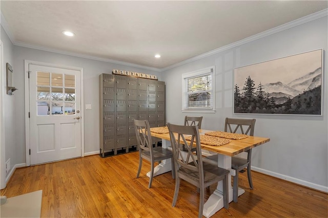 dining space featuring light hardwood / wood-style flooring and crown molding