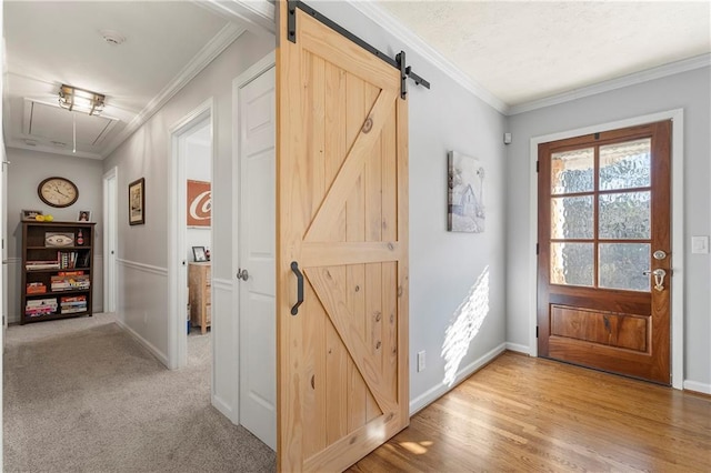 doorway featuring light colored carpet, crown molding, and a barn door