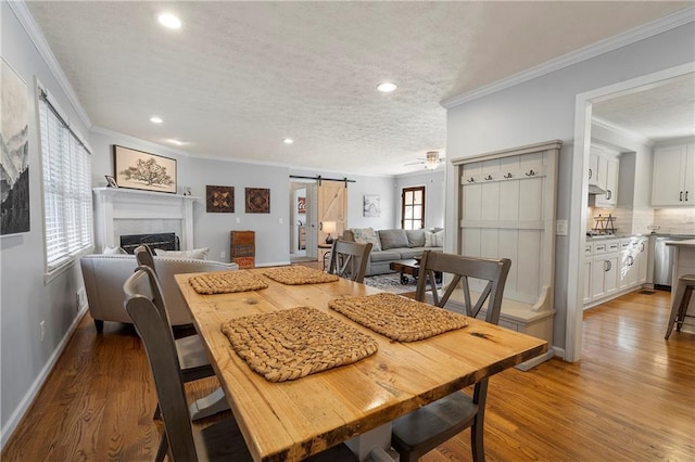 dining room featuring a textured ceiling, hardwood / wood-style floors, a barn door, and plenty of natural light