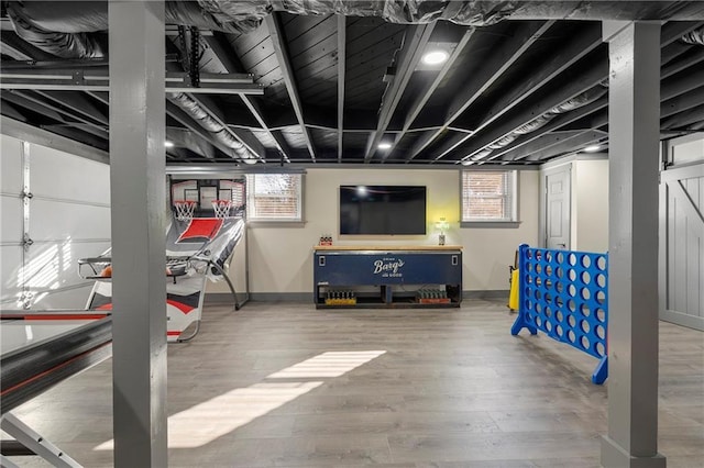 basement featuring a healthy amount of sunlight and hardwood / wood-style floors