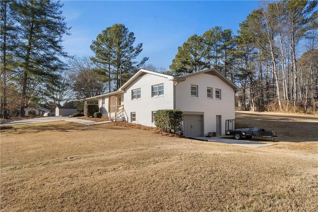 view of side of property featuring a garage and a lawn