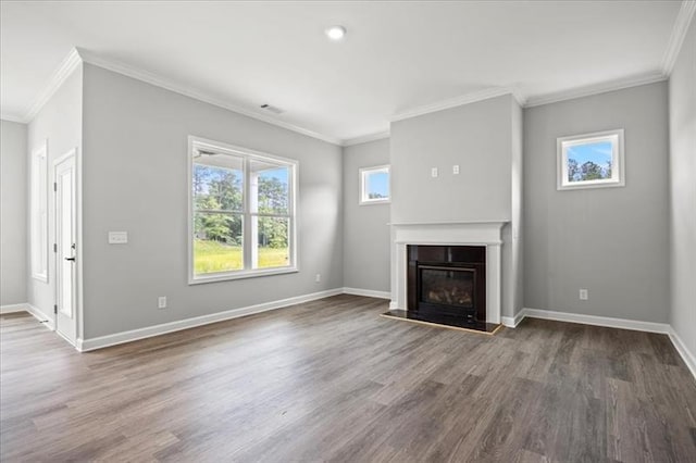 unfurnished living room with crown molding, visible vents, a glass covered fireplace, wood finished floors, and baseboards