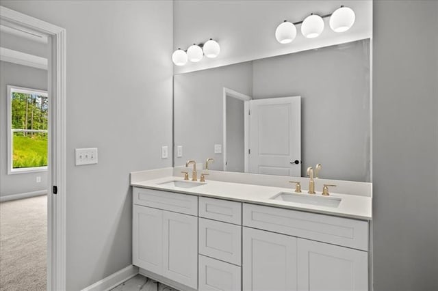 full bathroom featuring double vanity, a sink, and baseboards