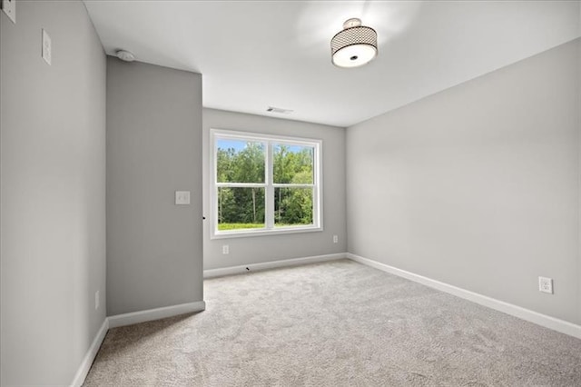 carpeted empty room with visible vents and baseboards