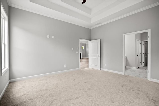 unfurnished bedroom featuring baseboards, connected bathroom, ornamental molding, carpet, and a tray ceiling