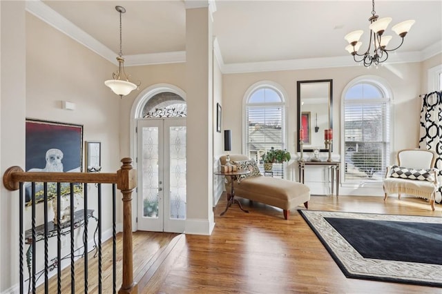 entryway featuring french doors, a healthy amount of sunlight, wood finished floors, and an inviting chandelier