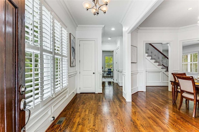 entrance foyer featuring a chandelier, dark wood-type flooring, and a healthy amount of sunlight