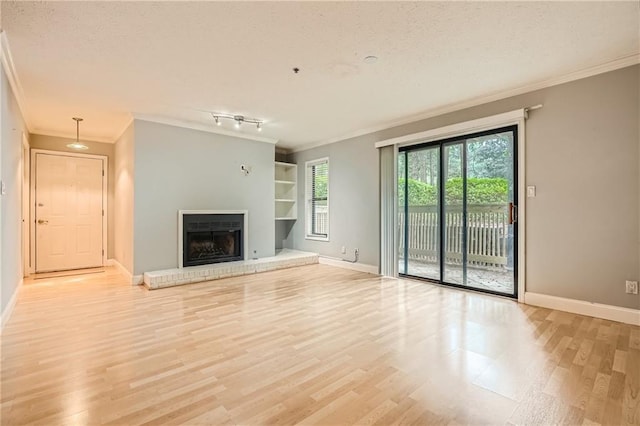 unfurnished living room featuring light hardwood / wood-style floors, a textured ceiling, built in features, and crown molding