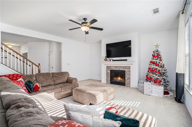 carpeted living room with ceiling fan and a brick fireplace