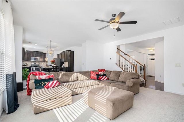 carpeted living room with ceiling fan