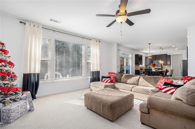 carpeted living room featuring ceiling fan