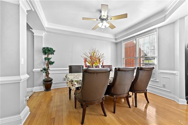 dining space featuring ornate columns, ceiling fan, light hardwood / wood-style flooring, and ornamental molding