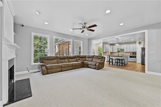 living room with ceiling fan and light carpet