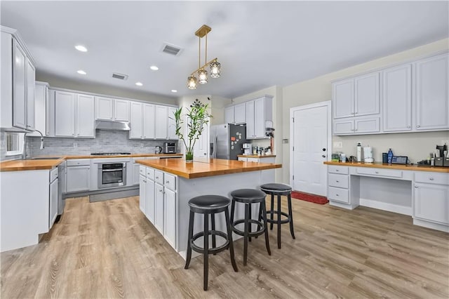 kitchen featuring white cabinetry and butcher block counters