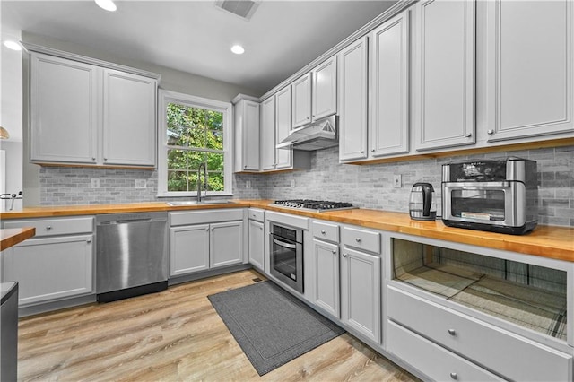 kitchen featuring wooden counters, stainless steel appliances, light hardwood / wood-style floors, and sink