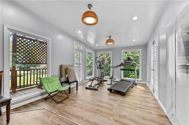 workout area with light wood-type flooring and french doors