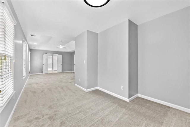 spare room with ceiling fan and light carpet