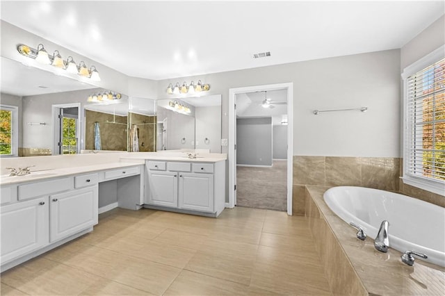 bathroom with vanity, tile patterned floors, ceiling fan, and tiled tub