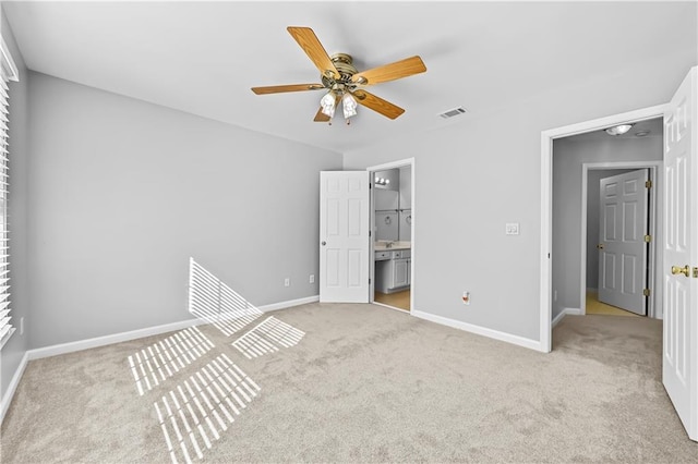 unfurnished bedroom featuring ceiling fan, light colored carpet, and ensuite bathroom