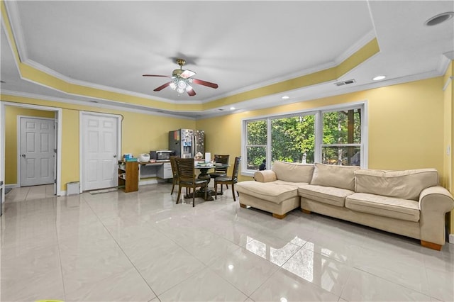 living room with a tray ceiling and crown molding