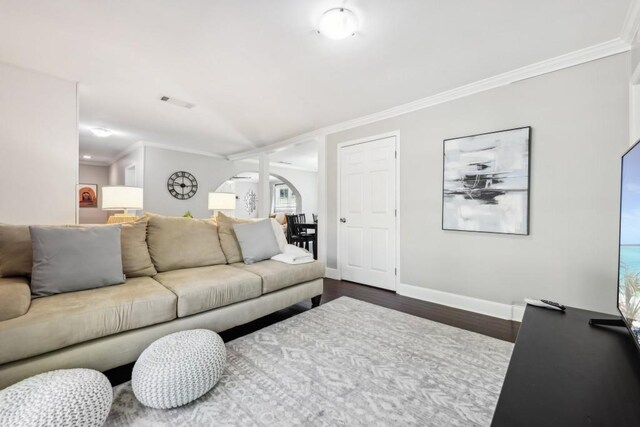 living room with ornamental molding and dark hardwood / wood-style flooring