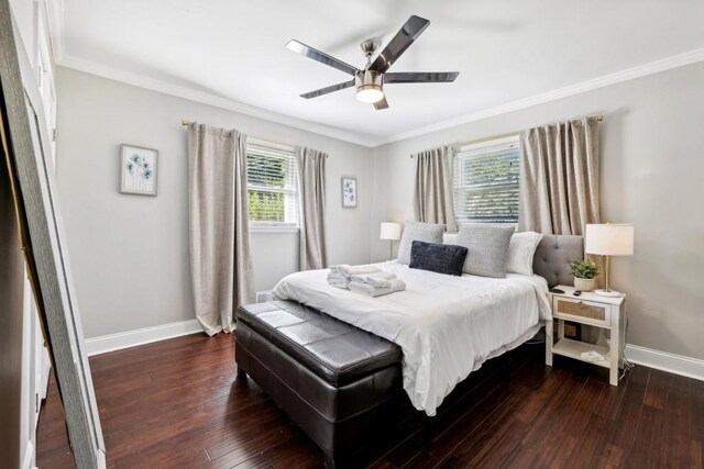 bedroom featuring dark hardwood / wood-style flooring, ornamental molding, and ceiling fan