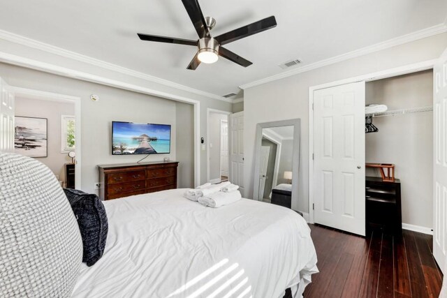 bedroom featuring crown molding, dark hardwood / wood-style floors, a closet, and ceiling fan