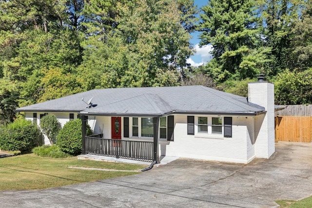 ranch-style house with covered porch and a front lawn