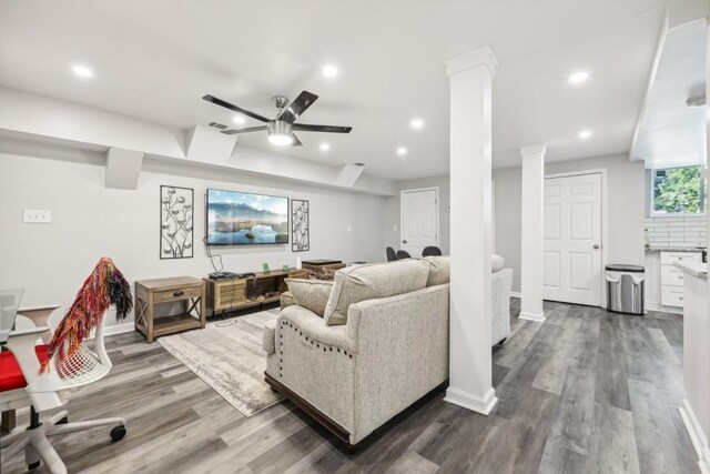 living room featuring hardwood / wood-style flooring, ceiling fan, and decorative columns