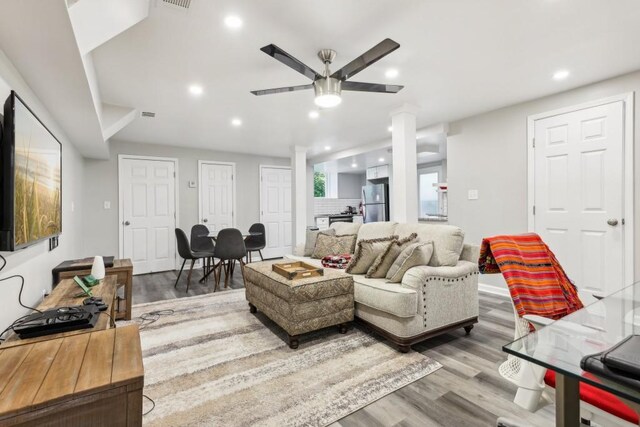 living room with ceiling fan, decorative columns, and hardwood / wood-style floors