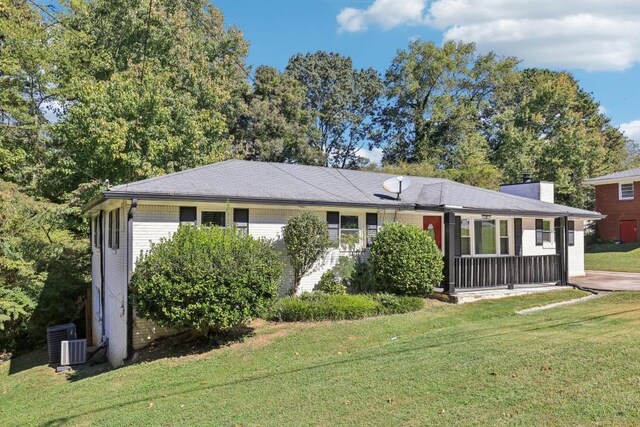 ranch-style home with a front yard and cooling unit