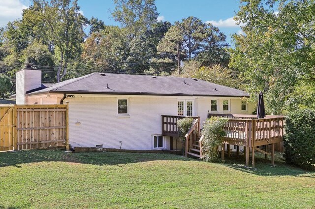 rear view of property featuring a yard and a wooden deck