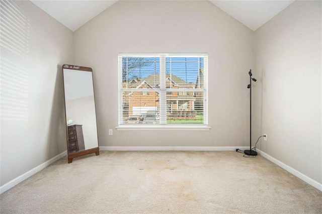 empty room with lofted ceiling and light colored carpet