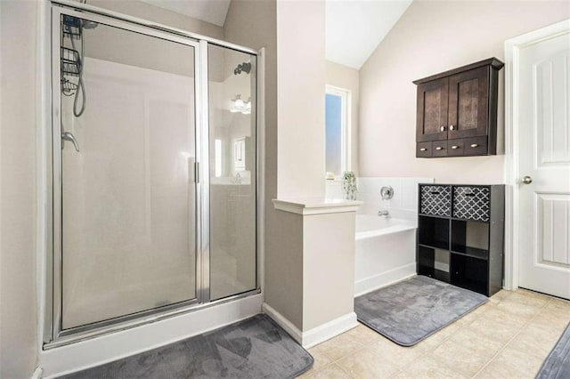 bathroom featuring separate shower and tub, vaulted ceiling, and tile patterned flooring