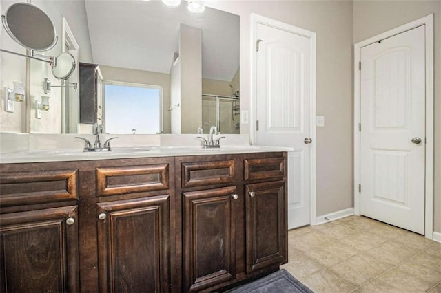 bathroom with vaulted ceiling, a shower with door, tile patterned floors, and vanity