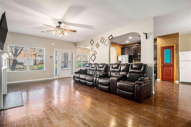 home theater room featuring ceiling fan and dark hardwood / wood-style floors