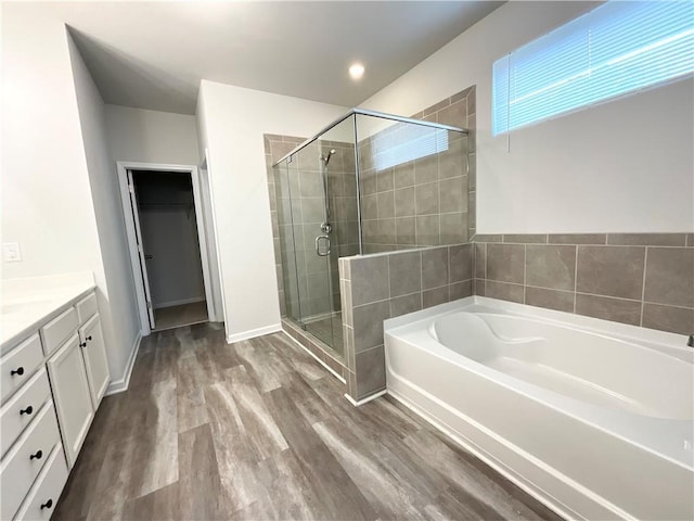 bathroom featuring vanity, hardwood / wood-style flooring, and shower with separate bathtub