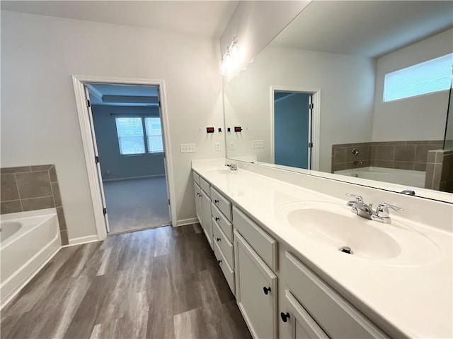 bathroom with hardwood / wood-style flooring, vanity, plenty of natural light, and a washtub